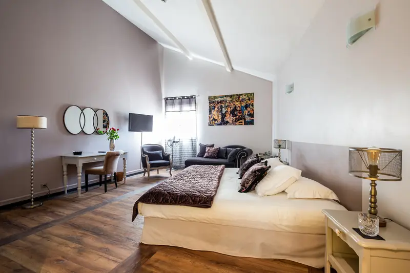 Chambre spacieuse avec lit double, bureau et coin salon au Clos de Meyre.