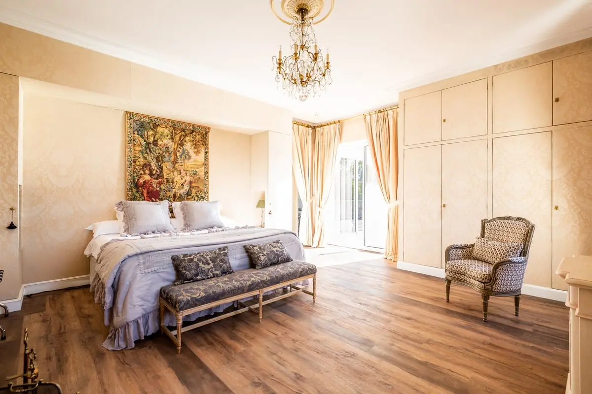 Lit double, banquette et fauteuil ancien dans la suite Colette du Clos de Meyre à Avensan.