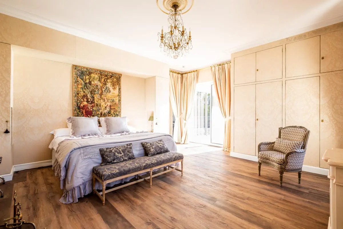 Lit double, banquette et fauteuil ancien dans la suite Colette du Clos de Meyre à Avensan.