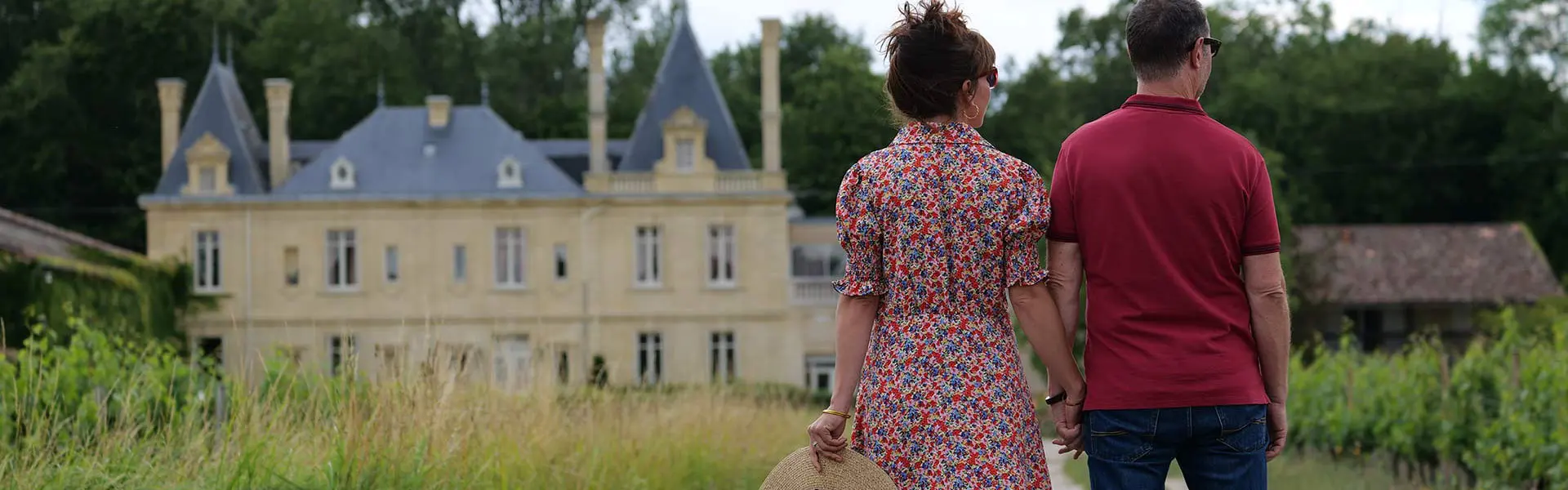 Couple marchant entre les vignes face au Château Meyre à Avensan.